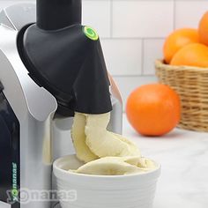 an orange juicer is being used to make fresh fruit and ice cream in a bowl