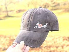 a person holding up a hat with the word local on it in front of a field