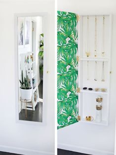 the inside of a white closet with green wallpaper and gold jewelry hanging on shelves