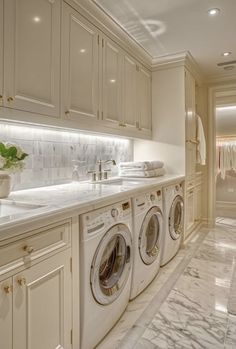 a washer and dryer in a very large room with marble flooring on the walls