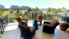 a balcony with wicker furniture and potted plants