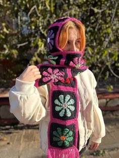 a woman wearing a pink scarf with flowers on it