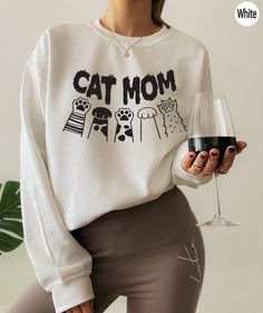 "Women's Cat Mom Sweatshirt, Cat Paws Shirt, Birthday Gifts for Cat Mom, Cat Mama Oversized Hoodie, Trendy Cat Love Shirt, Kitten Shirt,D5975 H O W  TO  O R D E R 1️⃣Please, check and review all the photos. 2️⃣ Choose your T-shirt size and color. 🔵Different styles of shirts may have different shades of same color choice due to different manufacturer brands. 🔵For this reason, we recommend you to match shirts from the same styles if you want precisely matching colors (ex. Unisex, V-necks, Toddle Cricut Shirt Ideas Women, Cat Merch, Cat Mom Sweatshirt, Cat Tee Shirts, Mom T Shirts, Cat Mom Shirt, Cat Mama, V Neck Shirts, Cat Mom Shirts