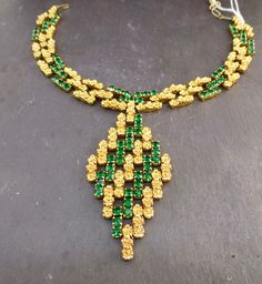 Item oxfj8 Price £125 Circa 1960 Wow this is an absolutely fabuuuuuulous necklace. This piece has a bold profile with vibrant emerald green stones and gold tone flowers, in a link design that moves and adjusts to your neckline when worn. The necklace has a substantial weight and feel and lies flush along your neckline when worn. Overall this is a well made and uniquely designed necklace. The diamond pendant measures approx. 8.5x4.5cm, the necklace measures 31cm extending to 35cm, 1.5cm wide. Green Jeweled Necklaces For Anniversary, Green Jeweled Necklace For Anniversary, Formal Green Emerald Necklace With Jewels, Green Hallmarked Emerald Necklace For Wedding, Luxury Gold Emerald Necklace For Party, Vintage Gold Emerald Necklace For Formal Occasions, Party Jewelry In Yellow Gold With Emerald, Green Emerald Pendant Necklace For Formal Occasions, Luxury Green Emerald Necklace For Party