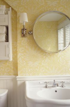 a white sink sitting under a bathroom mirror