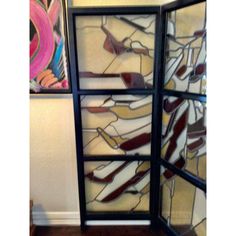 two stained glass windows sitting on top of a hard wood floor next to a wall