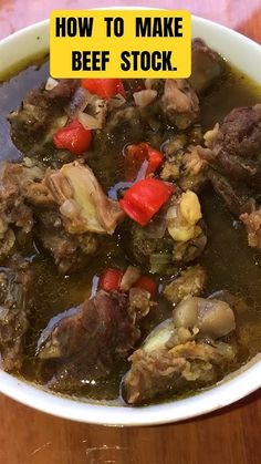 a white bowl filled with meat and vegetables on top of a wooden table next to a yellow sign that says how to make beef stock