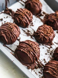 chocolate truffles are sitting on a baking sheet and drizzled with chocolate