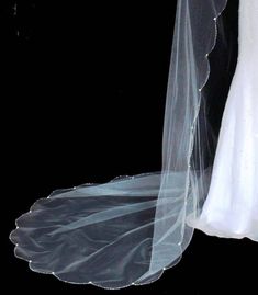 a bride's wedding dress and veil are photographed against a black background in this image