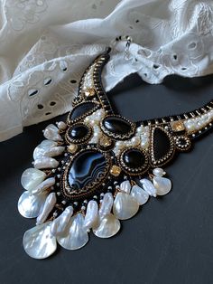 a black and white necklace with pearls on it