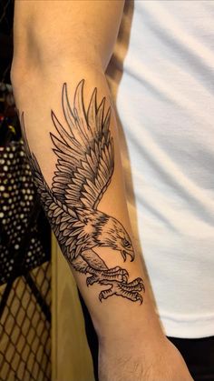 a man with a tattoo on his arm holding an eagle