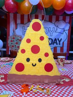 Small pepperoni pizza piñata sitting on the table with red and white plaid table cover and balloons at top of the screen Pizza Pinata Diy, Pizza Pinata, Pizza Themed Birthday Party