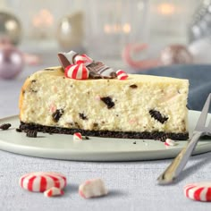 a slice of cheesecake on a plate with candy canes and pepperminks