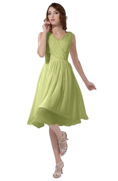 a woman in a green dress is talking on her cell phone and posing for the camera