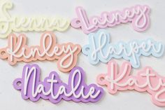 some type of name stickers on a white surface with pink, blue, yellow and purple