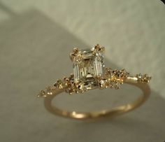 an engagement ring with a fancy green diamond in the center and yellow diamonds around it