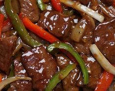 meat and vegetables are mixed together in a stir - fry dish with sauce on top