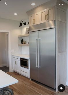 a stainless steel refrigerator in a white kitchen