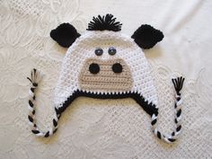 a crocheted cow hat laying on top of a bed