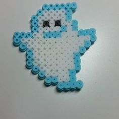 a blue and white beaded brooch sitting on top of a table