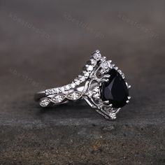 a black and white diamond ring on top of a stone