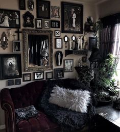 a living room filled with lots of framed pictures on the wall and a couch in front of it