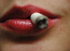 a woman's lips with a fake white object sticking out of her mouth to the side