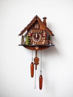 a wooden cuckoo clock hanging from the side of a wall