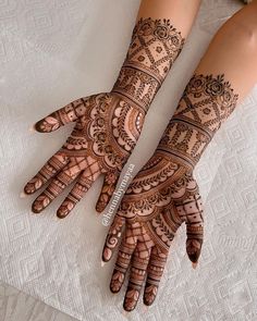 two hands with henna tattoos on them