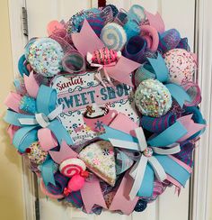 a wreath is hanging on the front door decorated with sweets and candies for sweet shop