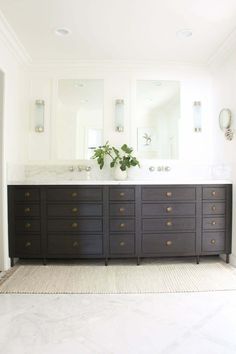 a large bathroom with two sinks and mirrors on the wall next to eachother