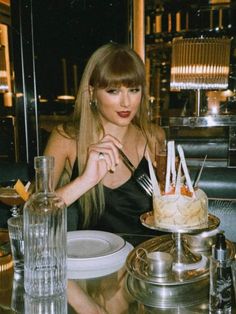 a woman sitting at a table in front of a cake with forks sticking out of it