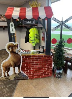 a fake ram standing in front of a brick wall with a red and white striped awning