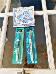 two blue and white items sitting on top of a window sill next to each other