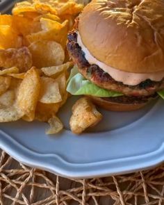 a hamburger and potato chips on a plate