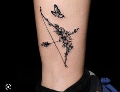 an arrow with flowers and a butterfly on the side of her leg, tattoo style