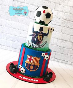 a three tiered cake decorated with soccer balls and other sports related items on top