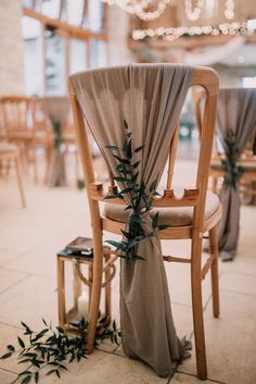 a chair with an olive branch on the back of it and some chairs behind it