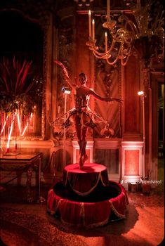 a statue is shown in front of a chandelier