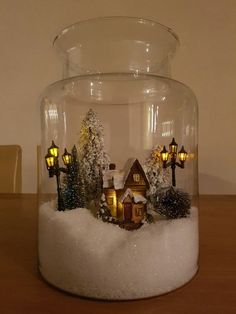 a glass jar filled with snow and small houses