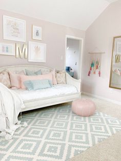 a white couch sitting on top of a rug in a living room next to a mirror