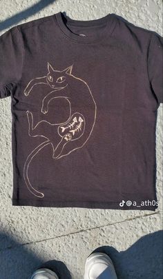 a person standing next to a t - shirt with a cat on it