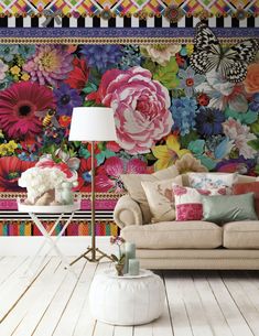 a living room with flowers on the wall and a couch in front of it,