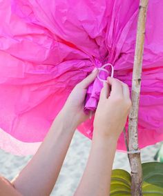 a person holding a pink umbrella on top of a tree