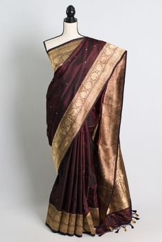 a maroon and gold silk saree on a mannequin