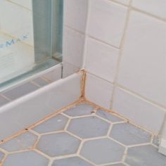 the corner of a bathroom with dirty tile