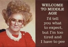 a woman with glasses and a red sweater is in front of a sign that says, welcome to middle age i'd tell you what to expect, but i'm too tired and i have to pee