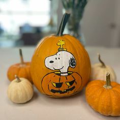 two pumpkins, one with a cartoon dog on it