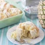 a pineapple cake on a plate with a fork next to it and another dish in the background