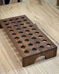 a wooden board with holes in it sitting on a table